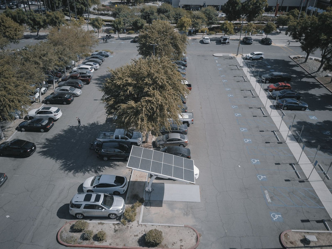 Aerial view zakelijk parkeerterrein met solar carport zonnepanelen en EV-laadpunten voor SPRILA subsidie 2026