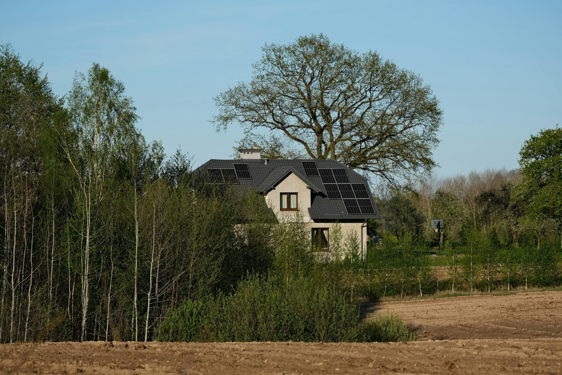 Moderne villa met zonnepanelen op leien dak, gelegen in een groene natuurlijke omgeving als premium thuisbasis voor een Deye SE-F16-C 16 kWh thuisbatterij