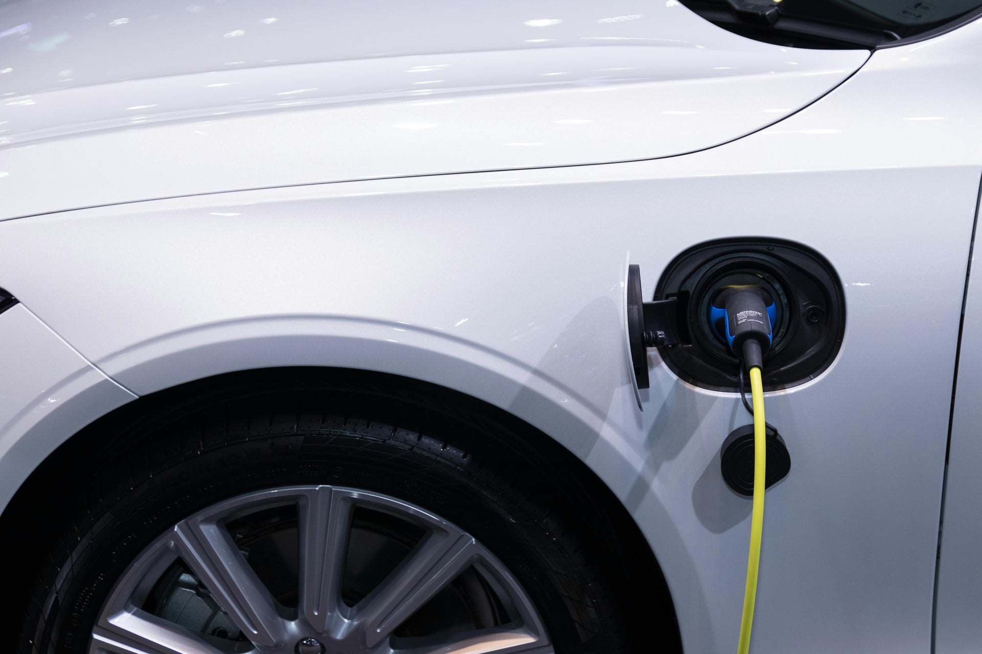 Close-up van een witte premium elektrische auto die thuis opgeladen wordt via een laadkabel, als basis voor ERE-certificaten voor zonne-energie thuisladen