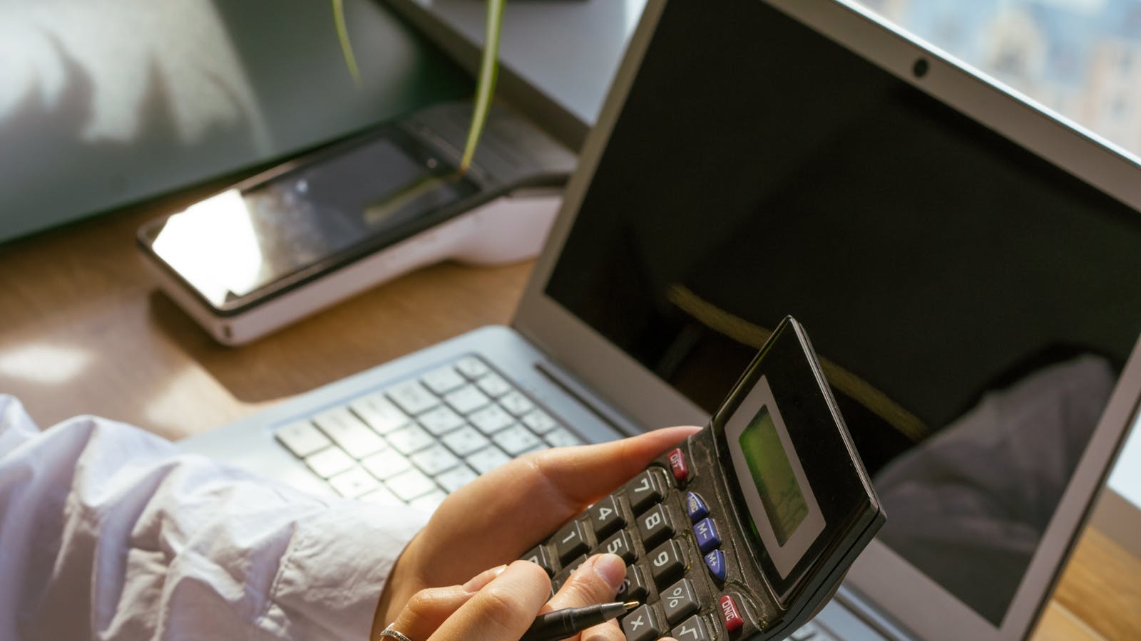 Ondernemer berekent EIA-fiscaal voordeel op calculator naast laptop voor bedrijfsbatterij-investering 2026