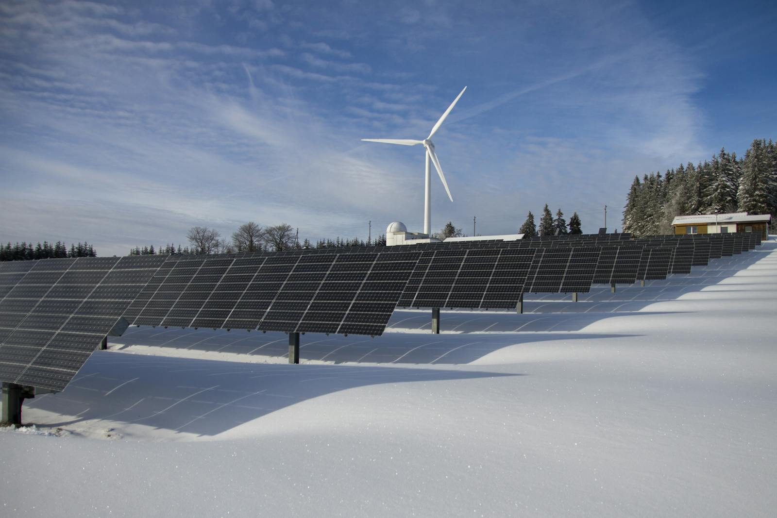 Wijds zonnepark met windturbine in een besneeuwd Nederlands landschap, symbool voor duurzame energieopslag en thuisbatterij-systemen via een officieel servicepunt.