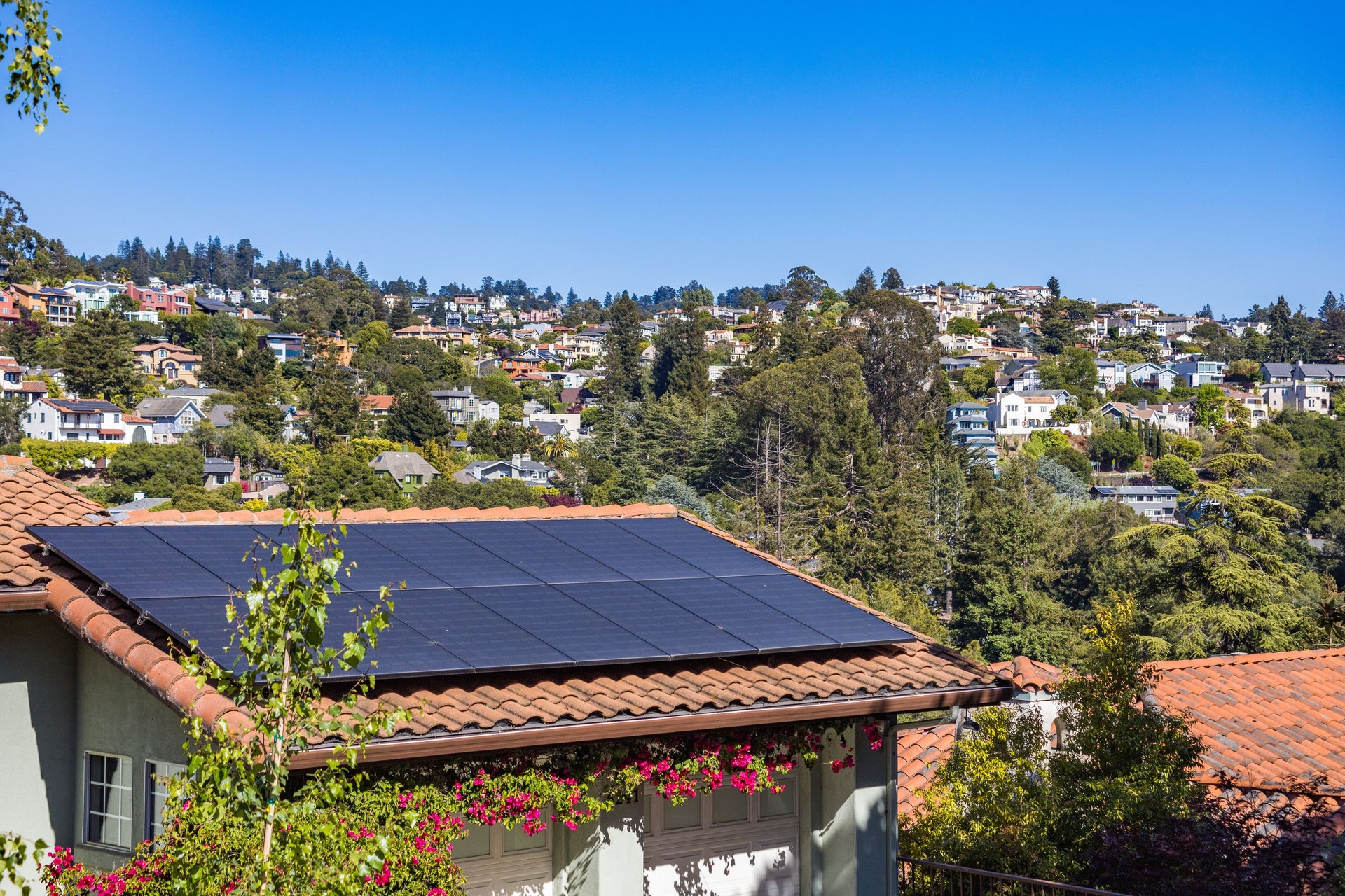 Woning met een dak vol egale all black zonnepanelen tegen een blauwe lucht, passend bij zonnepanelen kiezen in 2026