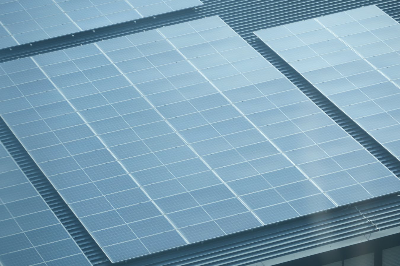 Aerial vergezicht van een woondak met meerdere zonnepaneel-arrays in een rasterpatroon, illustratief voor de Deye SUN-modellen vergelijking 2026