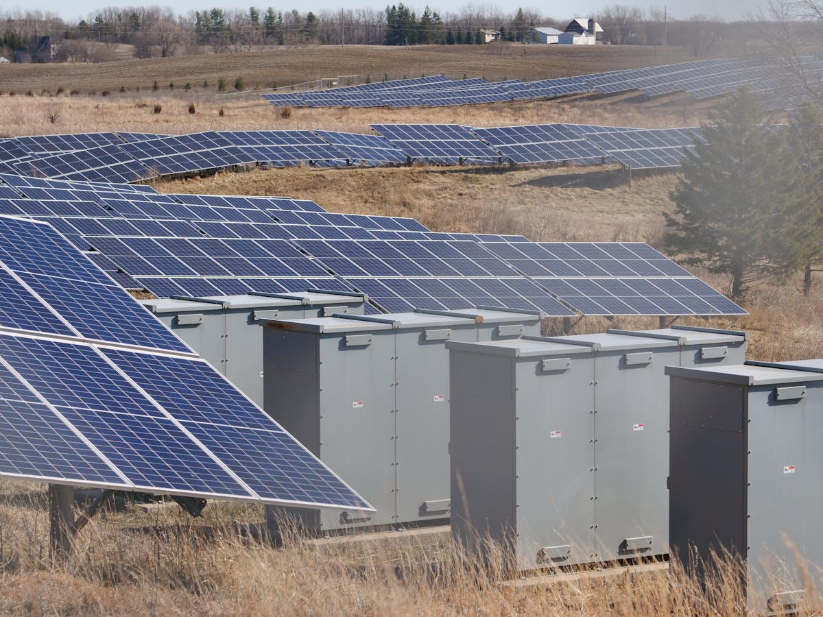 Wijds zonneveld onder een heldere blauwe lucht in een rural landschap, beeld bij de vergelijking tussen Deye en Sungrow hybride omvormers in 2026