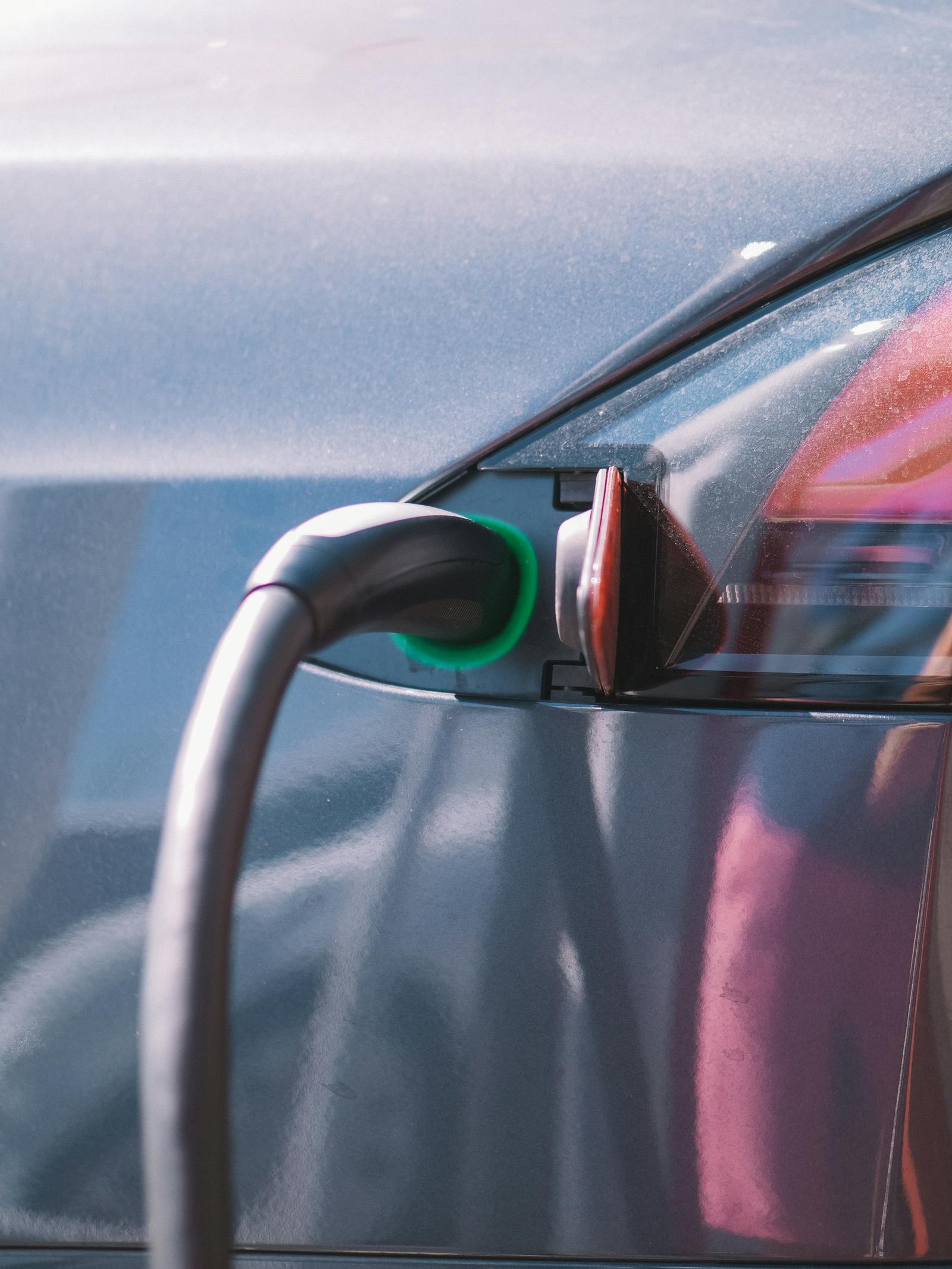 Close-up laadkabel in de laadpoort van een elektrische auto met groene LED, beeld bij vehicle to grid Nederland 2026